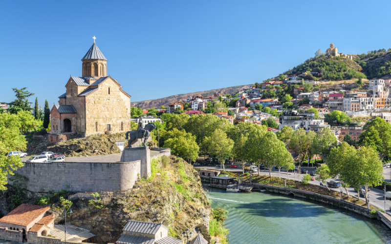 Iglesia de Metekhi, con las casas del casco antiguo de Tiflis y la fortaleza de Narikala enfrente